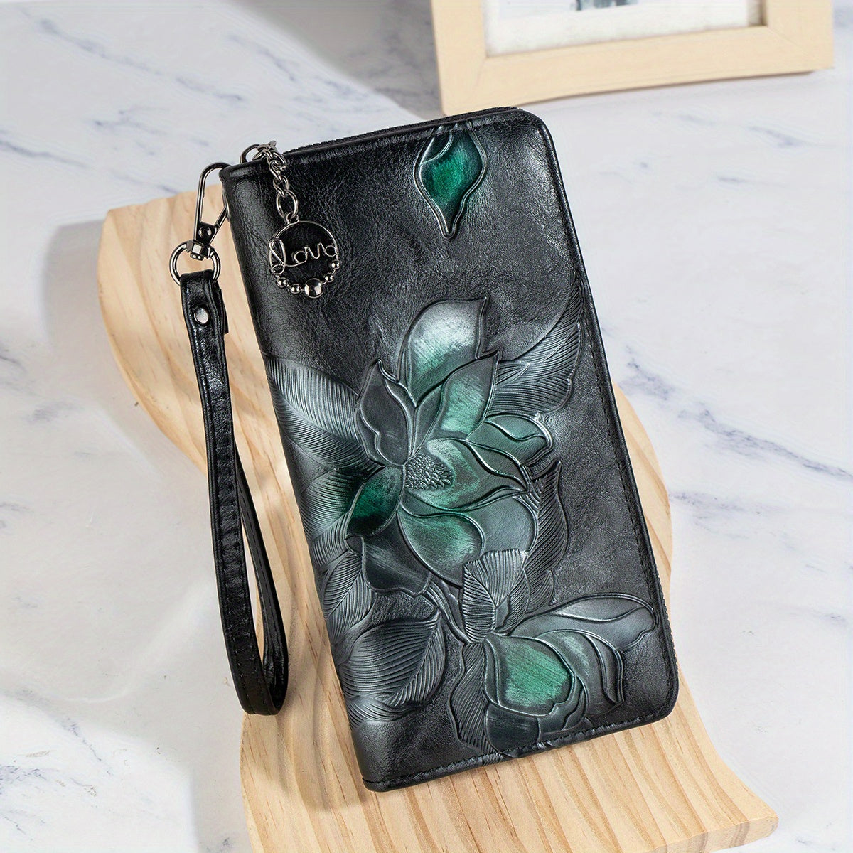 Faux leather clutch wallet with floral embossing, wristlet, zipper closure, multi-card compartment, phone pocket, and long purse design.