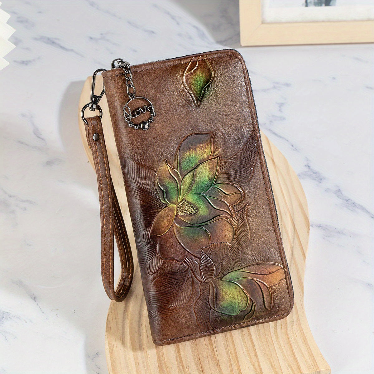 Faux leather clutch wallet with floral embossing, wristlet, zipper closure, multi-card compartment, phone pocket, and long purse design.