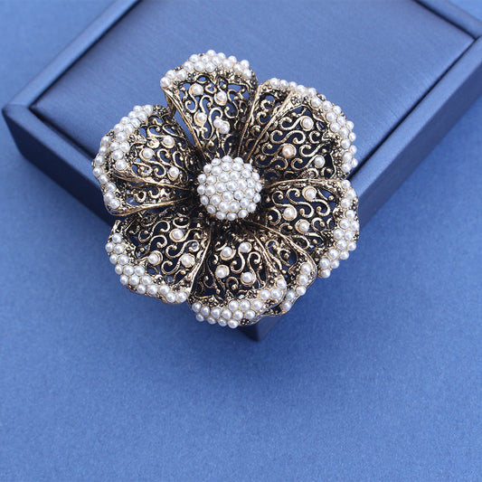 Elegant and simple, this Vintage Alloy Pearl Hollow-Out Flower Brooch Pin is the perfect accessory for women. Wear it on your sweater, shawl, or lapel for a touch of vintage sophistication.