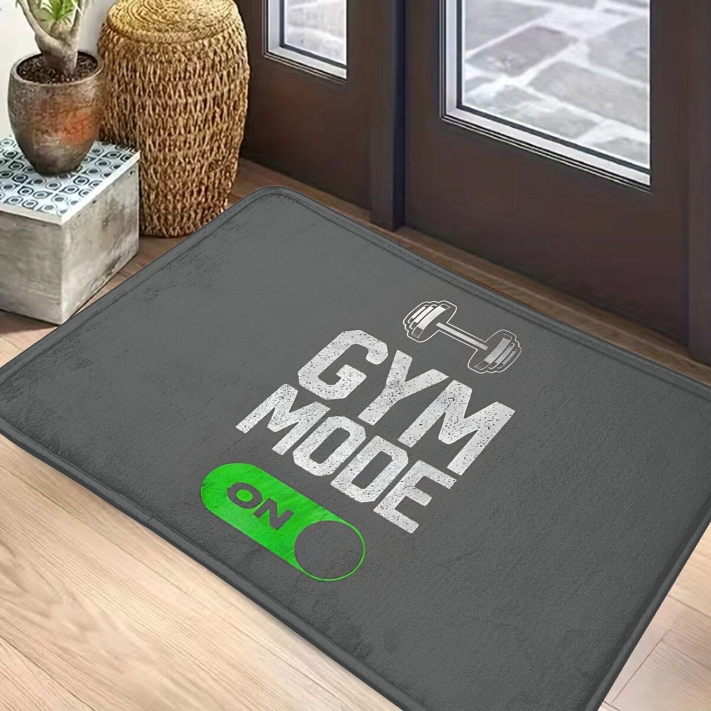 Polyester doormat with non-slip backing that is machine washable. Features a "Gym Mode Activated" design, suitable for bathroom, kitchen, and entrance. This lightweight rectangular floor mat is perfect for home decor.