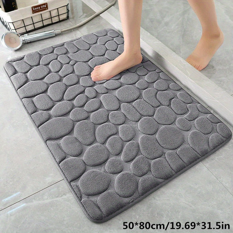 This memory foam bath rug features an embossed cobblestone design and is designed to be super absorbent and non-slip. Made from a polyester blend, it is suitable for use in the bathroom, toilet, kitchen, and laundry. The rug measures 100gsm and is 0.5cm