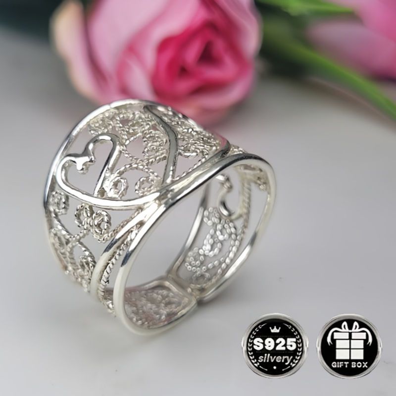 A collection of stylish rings including a delicate filigree design, a bold cigar band, a wide silvery band, a heart-shaped ring made of 925 sterling silver, a thick silvery band, and a bohemian-style ring. This filigree art jewelry is perfect for adding