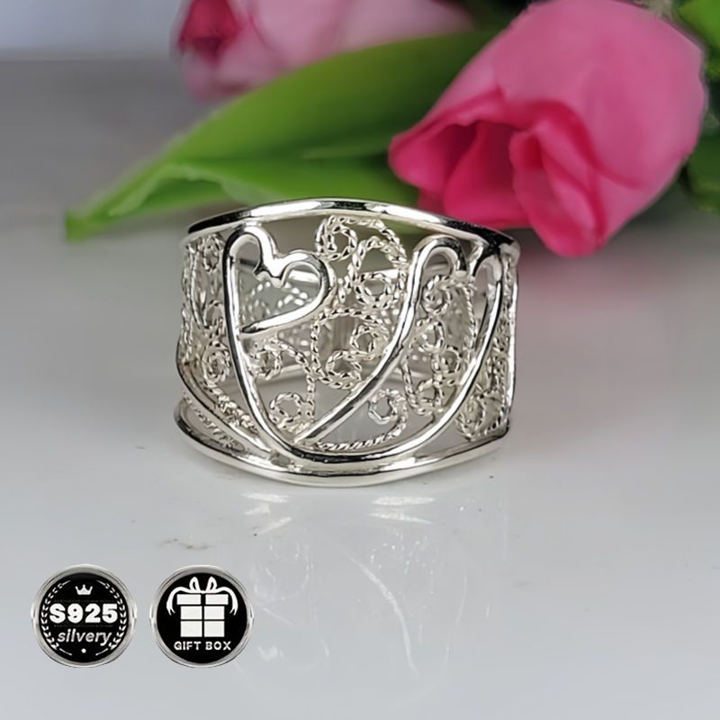 A collection of stylish rings including a delicate filigree design, a bold cigar band, a wide silvery band, a heart-shaped ring made of 925 sterling silver, a thick silvery band, and a bohemian-style ring. This filigree art jewelry is perfect for adding