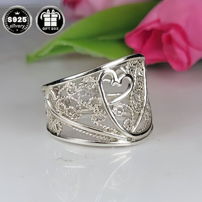 A collection of stylish rings including a delicate filigree design, a bold cigar band, a wide silvery band, a heart-shaped ring made of 925 sterling silver, a thick silvery band, and a bohemian-style ring. This filigree art jewelry is perfect for adding