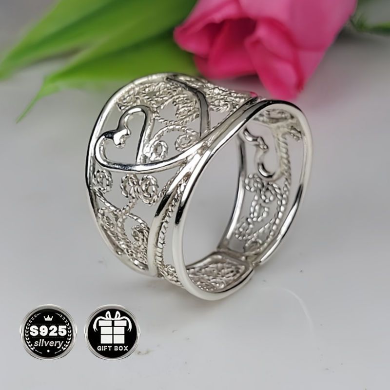 A collection of stylish rings including a delicate filigree design, a bold cigar band, a wide silvery band, a heart-shaped ring made of 925 sterling silver, a thick silvery band, and a bohemian-style ring. This filigree art jewelry is perfect for adding