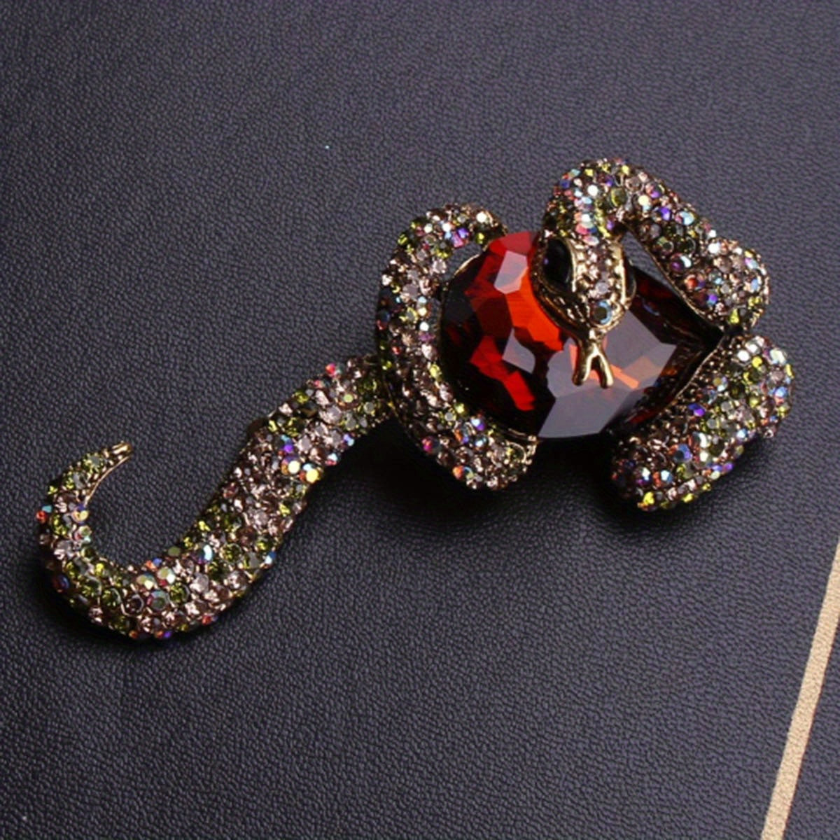 Luxurious punk style enamel snake brooch featuring stunning inlaid zirconia, perfect for both men and women. This unique animal pin adds a touch of irregular shape fashion to any party or banquet outfit. Ideal accessory for a stylish suit or coat.