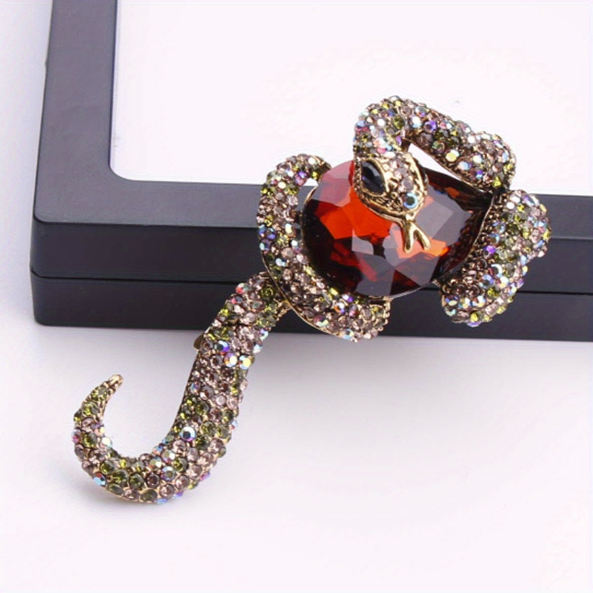 Luxurious punk style enamel snake brooch featuring stunning inlaid zirconia, perfect for both men and women. This unique animal pin adds a touch of irregular shape fashion to any party or banquet outfit. Ideal accessory for a stylish suit or coat.