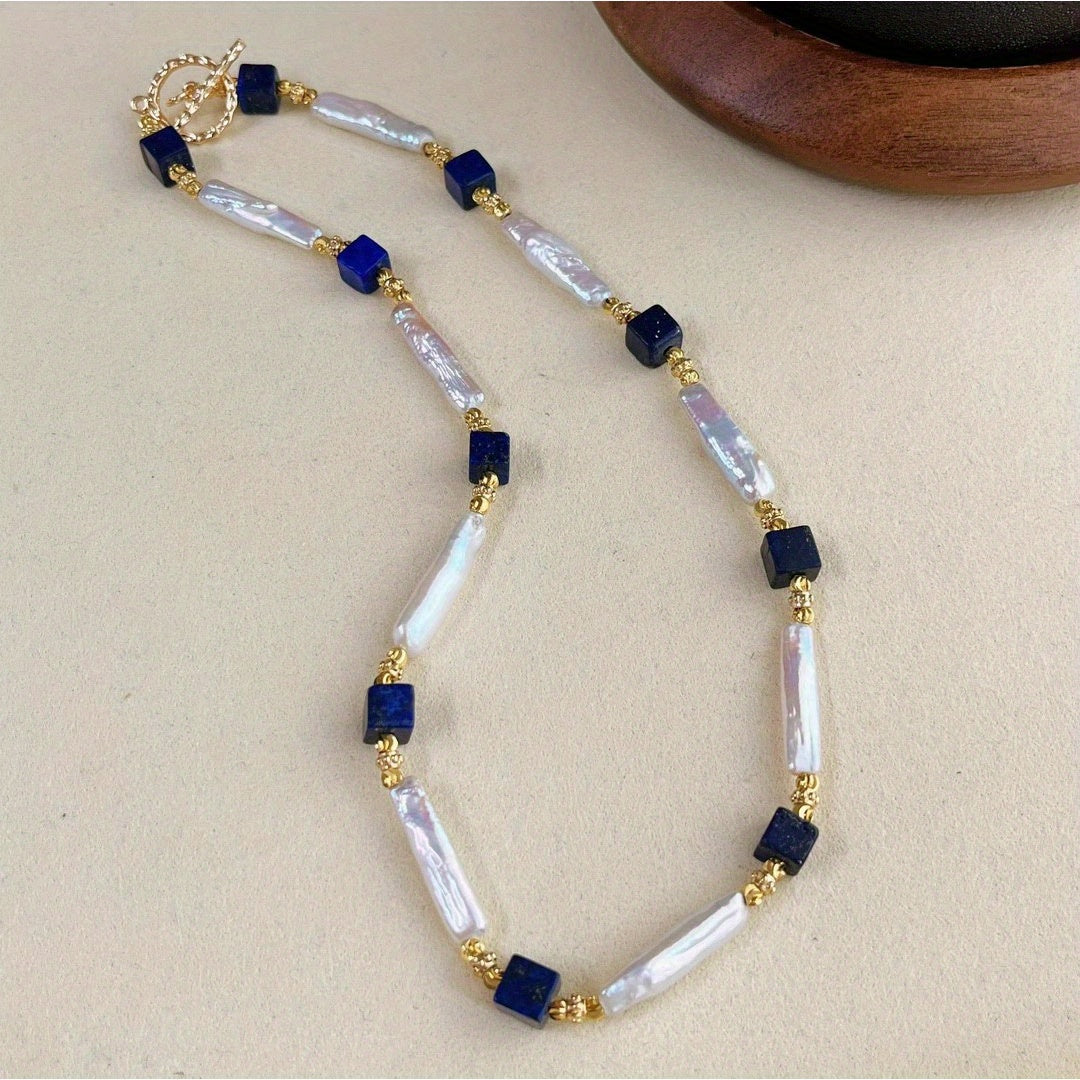 A sophisticated necklace with a vintage charm, featuring Baroque pearls and Lapis Lazuli stones in a Bohemian style. Made with natural freshwater pearls showcasing unique growth flaws, this piece is a stunning addition to any women's fashion collection.