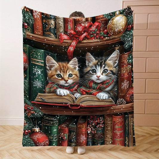 One piece of a mid-century style flannel blanket featuring Christmas kittens reading on a shelf. This soft knit throw weighs 200-250g and is digitally printed. Perfect for use on a bed, sofa, office, or while camping, this all-season blanket has a