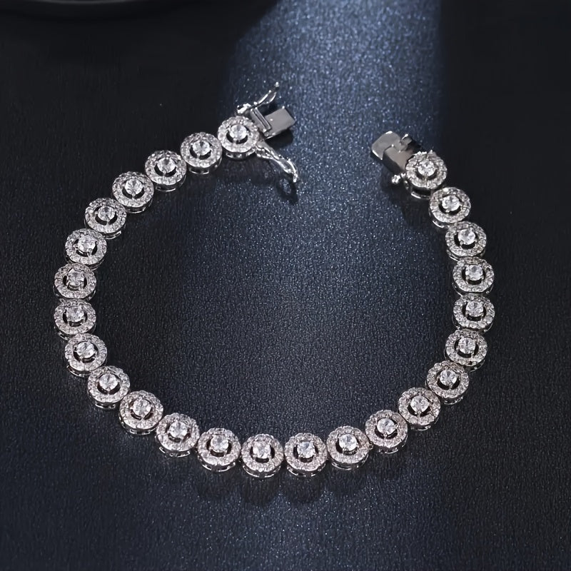 A timeless and sophisticated silver tennis bracelet featuring Moissanite gemstones, exuding a sultry charm and versatile appeal for year-round wear. This stunning piece is perfect for daily adornment or as a thoughtful gift, made with silver plating and