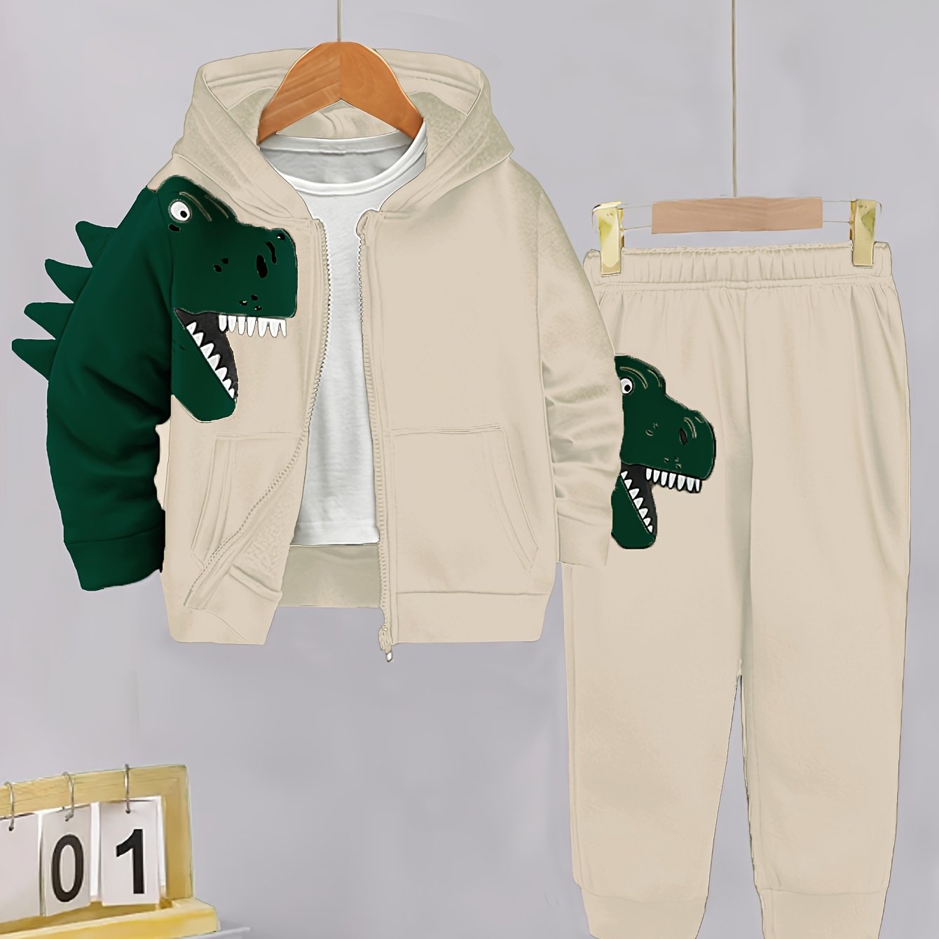 2-piece toddler set with fleece-lined hoodie and pants featuring dinosaur pattern. Perfect for autumn/winter outdoor activities, soft, cozy, and machine washable.