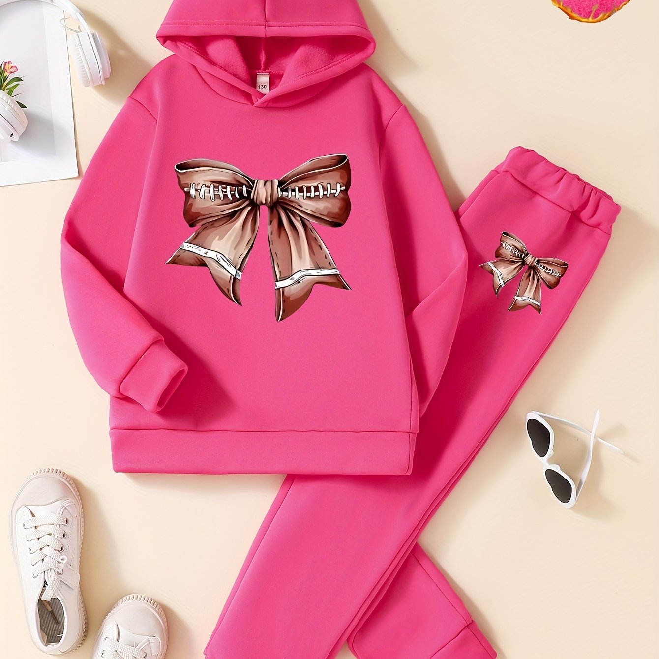 Cozy and stylish girls' 2-piece set featuring fleece-lined hoodie with bow design and matching joggers, ideal for fall/winter and outdoor activities.