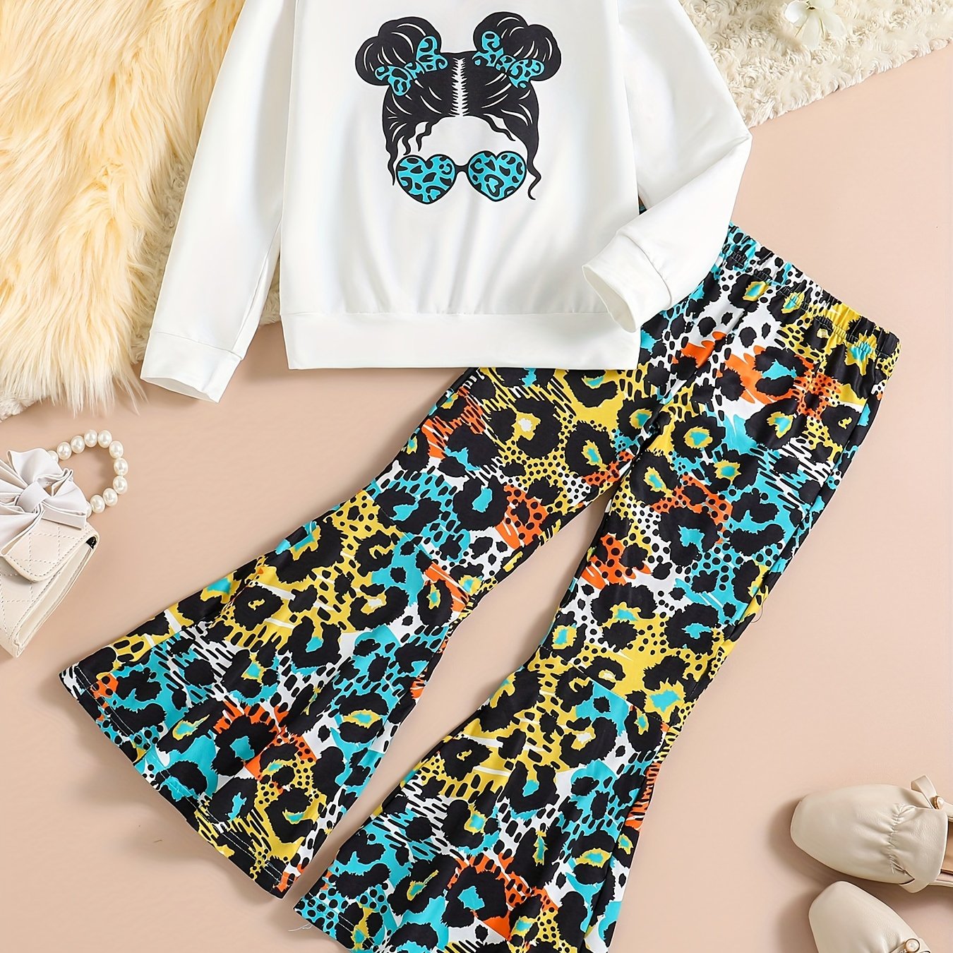 Girls' trendy 2-piece outfit includes a sweatshirt, leopard pattern flared pants, and sunglasses print. Perfect for spring and fall outdoor wear.