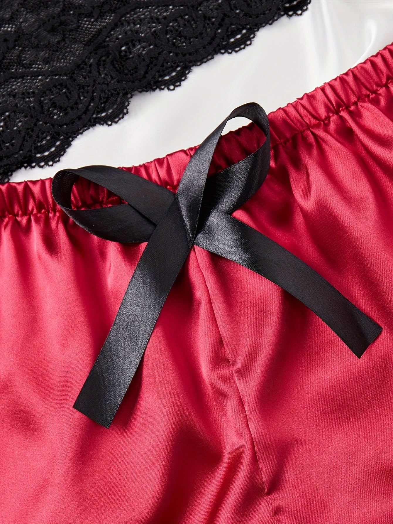 A Polyamide and elastane lingerie set with bow detail, solid color, and mid-rise trunks for medium support, suitable as adult nightwear.