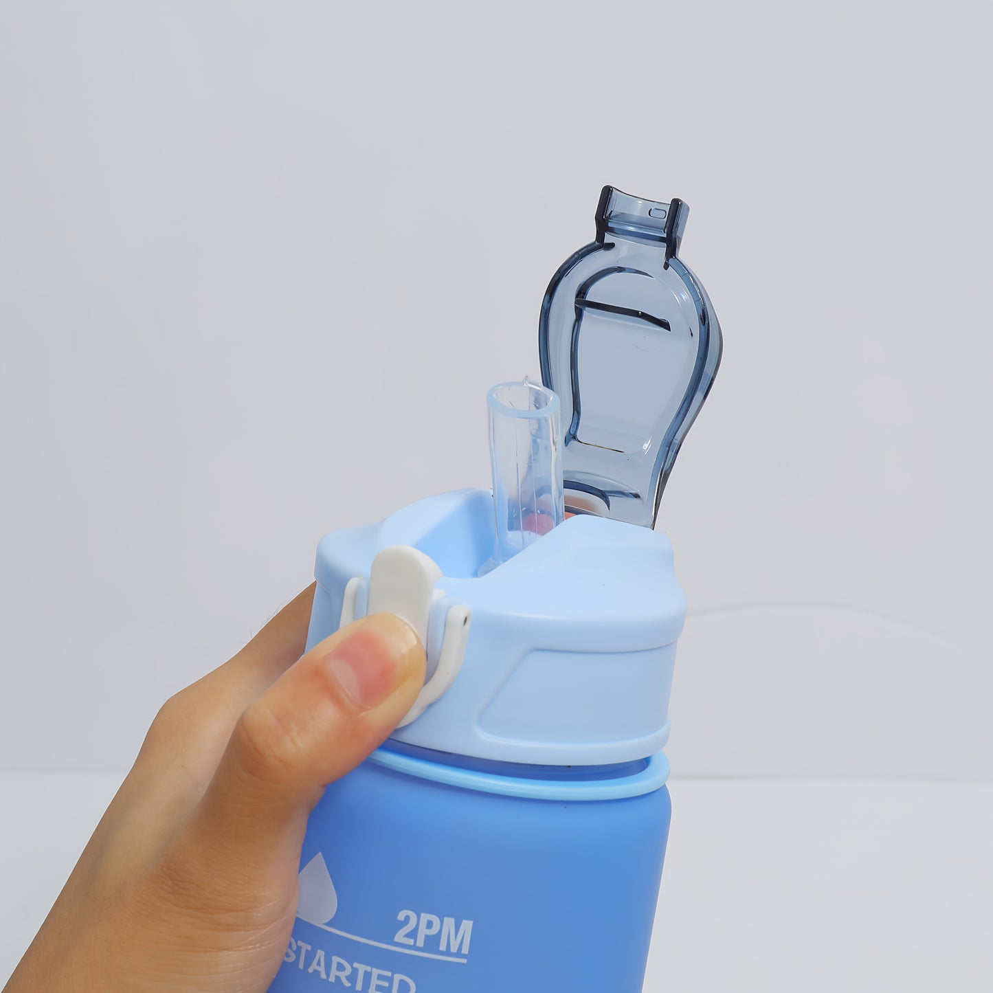 Two BPA-free plastic water bottles with time stamp and straw, lightweight and round with fixed hand strap. Hand wash only. Ideal for sports and daily use.