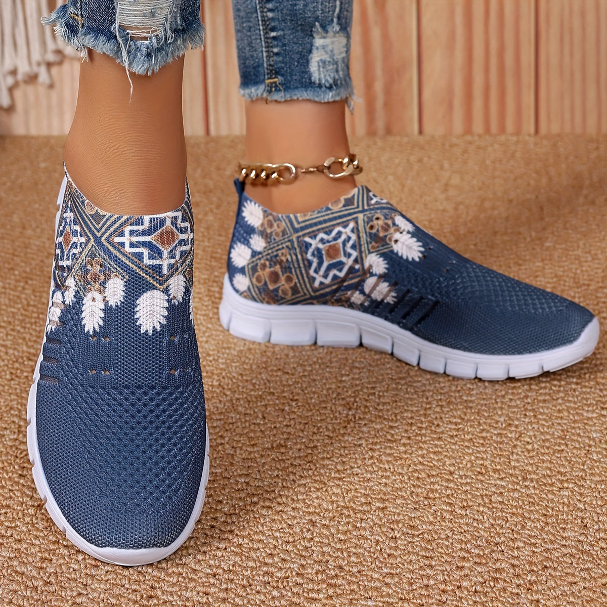 Women's casual slip-on sneakers in blue knit fabric with white floral and geometric patterns, featuring a lightweight EVA sole and breathable low-top design. Perfect for everyday wear with