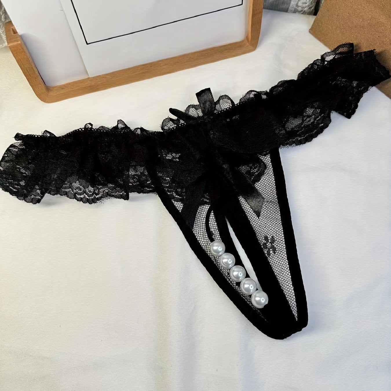 Double-bow, sexy, transparent, hot, lace crotchless thong with pearl massage detail.