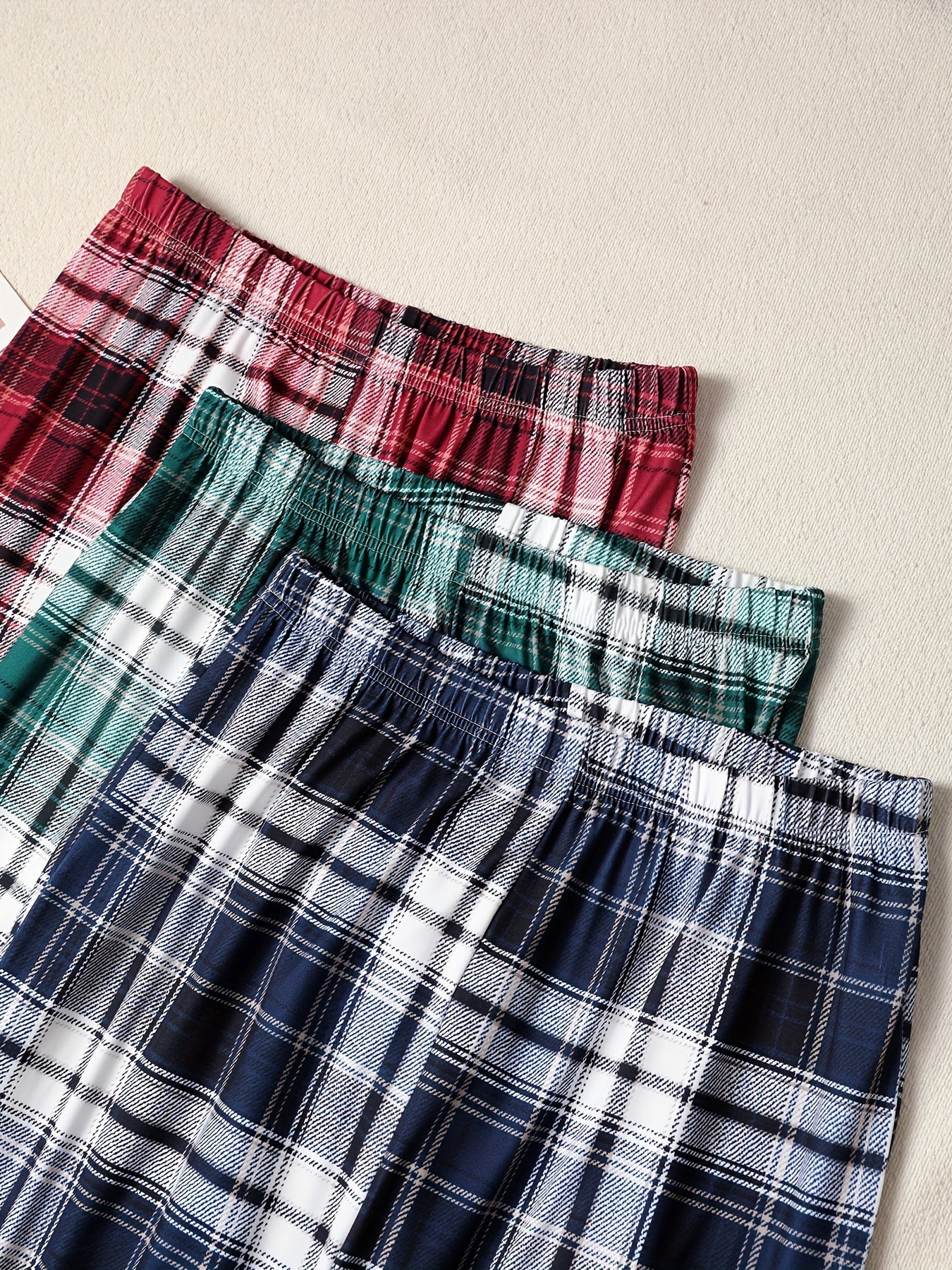 3-pack of men's plaid pajama pants with comfortable medium stretch knit fabric in assorted designs.