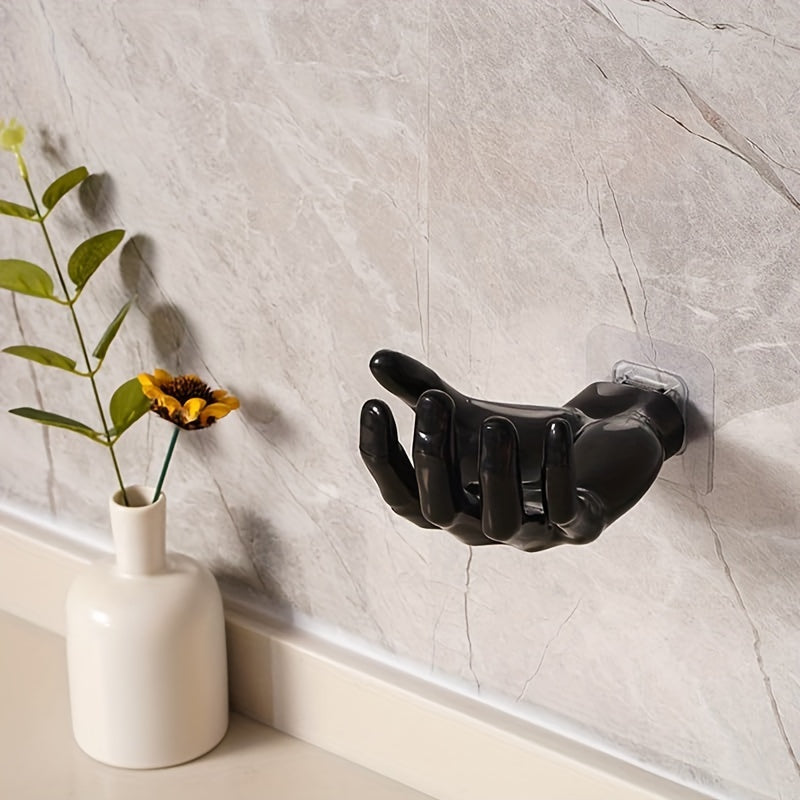 Palm-shaped adhesive wall hook for strong, no-drill, traceless storage of keys and headphones at home.