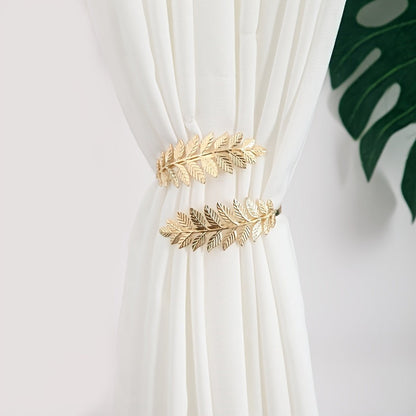 A decorative curtain tieback with gold accents, adorned with branches, leaves, and leaf-shaped hooks, perfect for enhancing home decor.