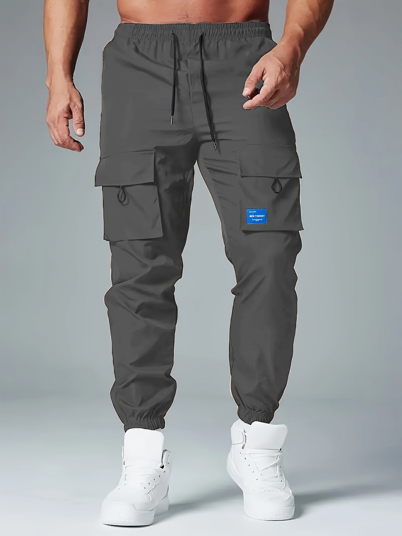 Men's casual drawstring cargo pants with multiple pockets made of polyester, mid-waist, ideal for spring and fall seasons.