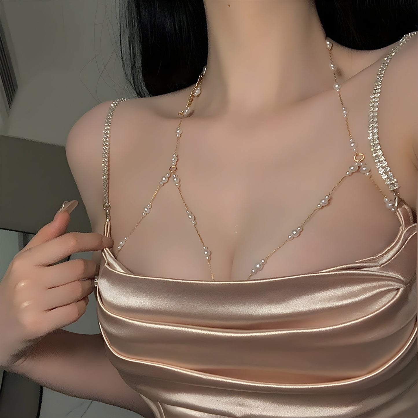 The woman personifies grace and refinement in a stunning body chain adorned with golden imitation pearls, ideal for adding a touch of glamour to any party or night out.