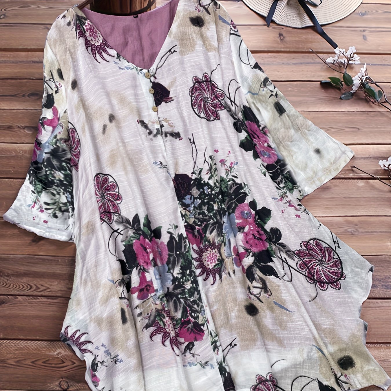 Women's plus size casual top with floral print, short sleeves, V-neck, and asymmetrical hem.