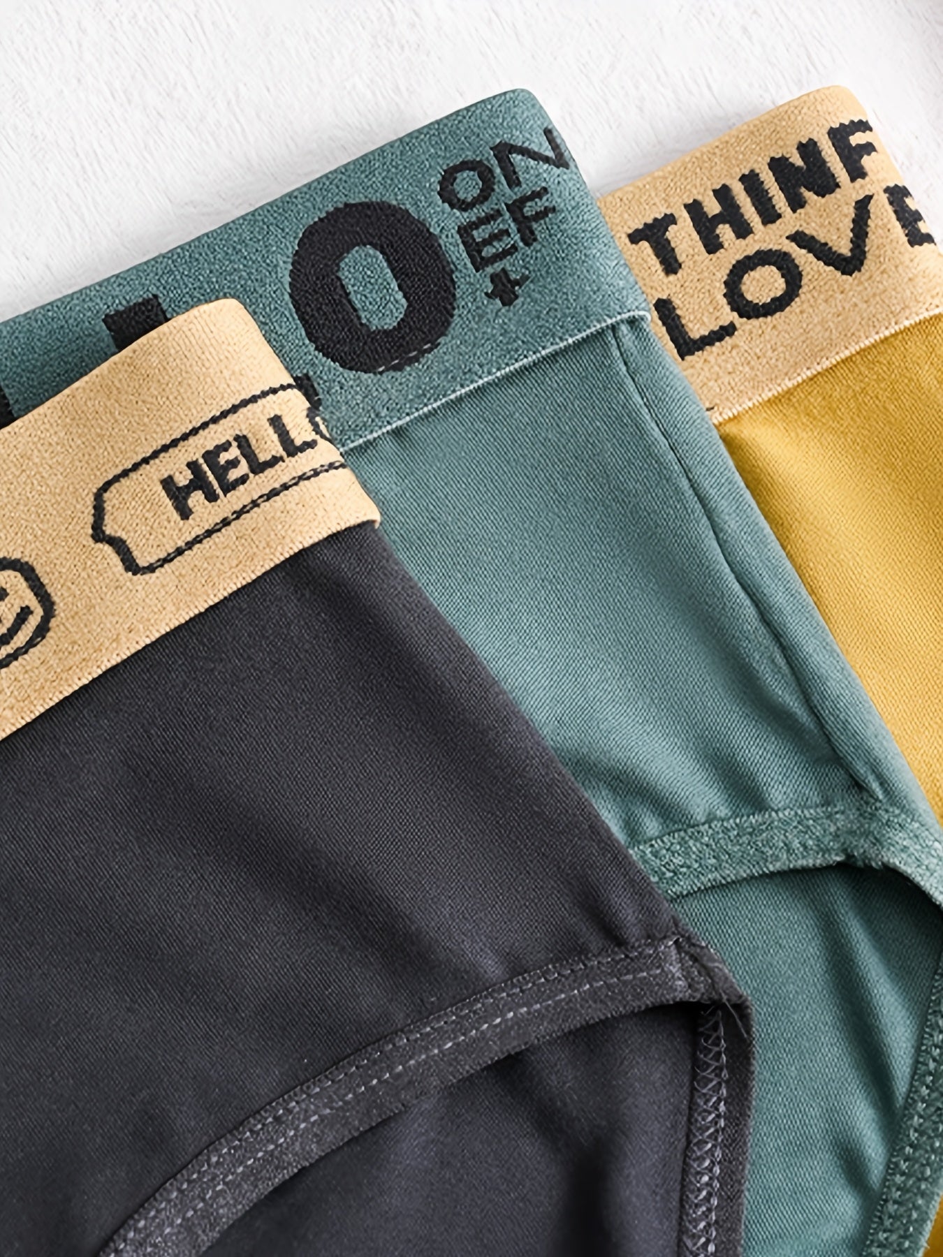 Four pairs of men's briefs with 'Hello' letter waistband in multiple solid colors, comfortable for daily wear.