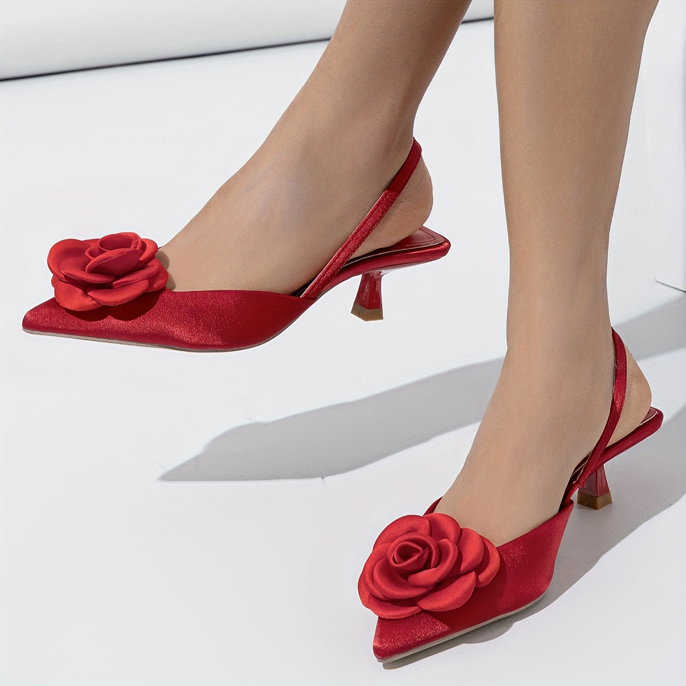 Pointed red high heel shoes with three-dimensional flowers, perfect for night weddings.