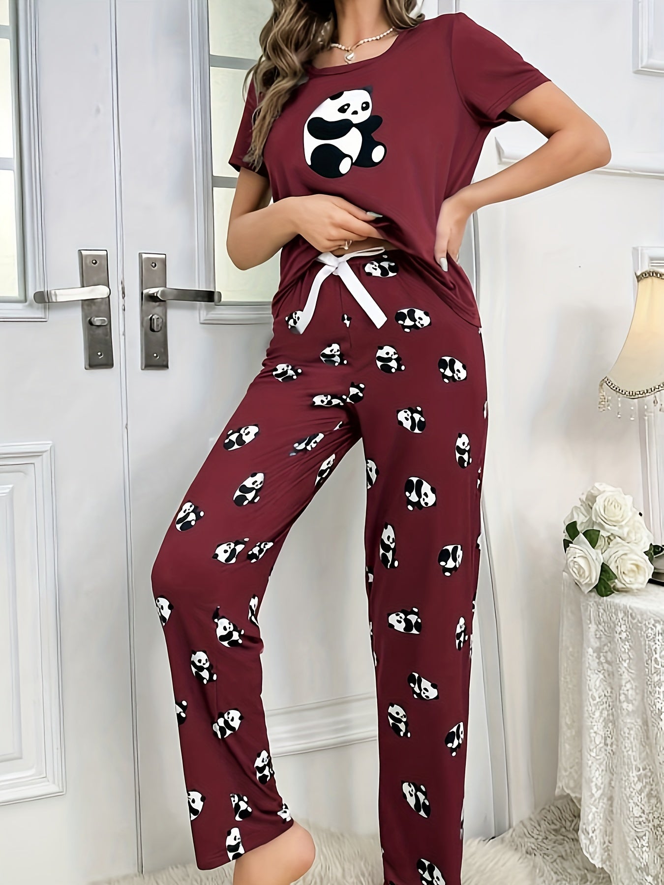 Women's sleepwear set with cute panda print, short sleeve top, and elastic pants.