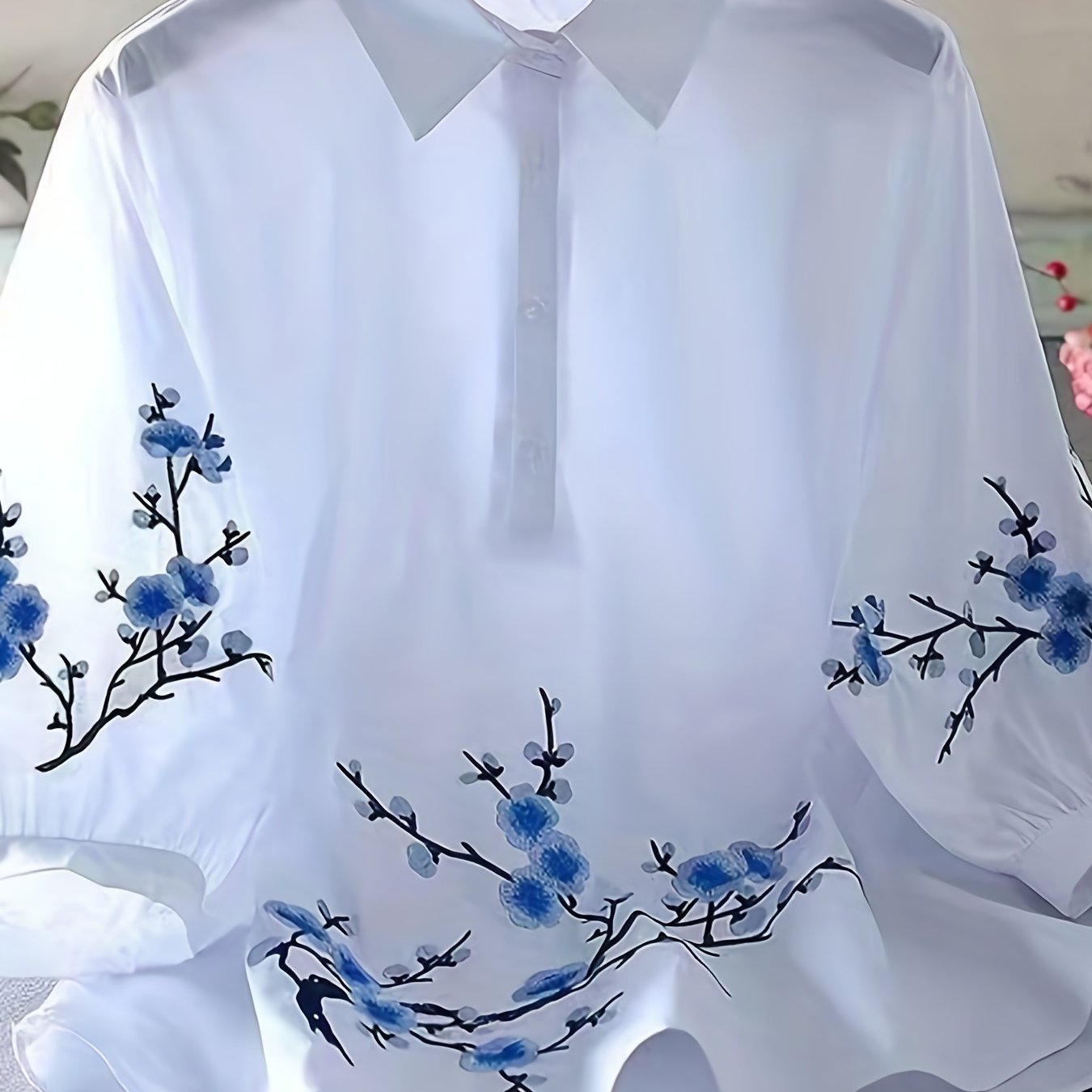 Embroidered blouse with elegant buttons and collar.