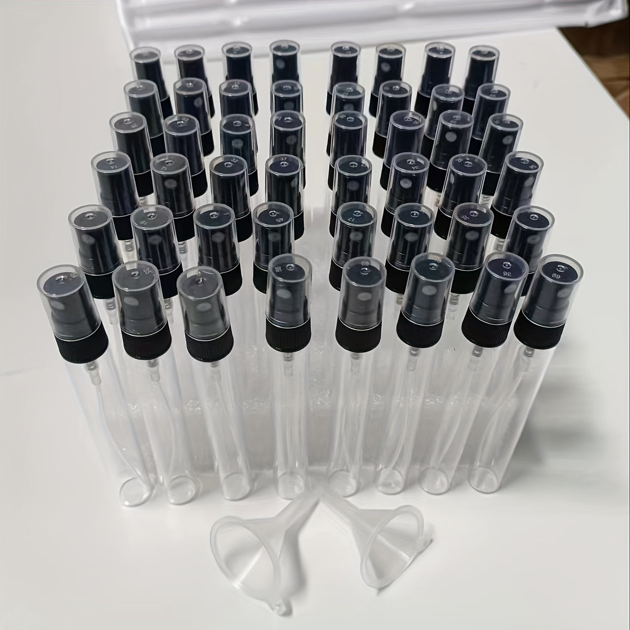 48 mini 10ml glass spray bottles in sleek black and transparent design, ideal for travel, perfect for perfumes, essential oils, and hydrating mist.