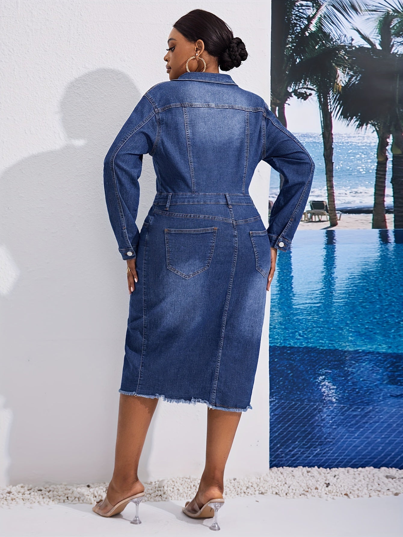 Kiki Angel offers a plus-size denim midi dress with a button-front, lapel collar, and frayed hem. Made from a cotton blend fabric, this solid color tunic is perfect for casual style in