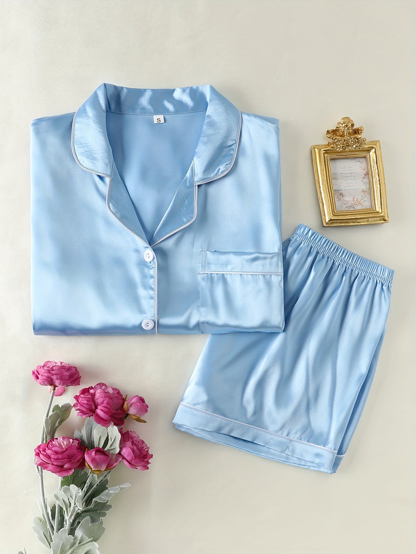 Satin lounge set includes a short sleeve button-up top with lapel collar and elastic shorts.