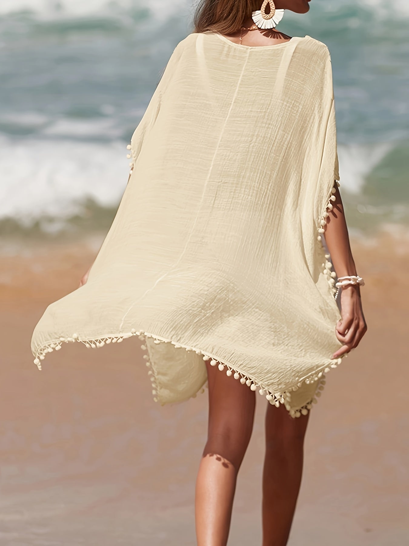 Bohemian style crochet cover up with batwing sleeves, side split, and sheer fabric for beach sun protection.