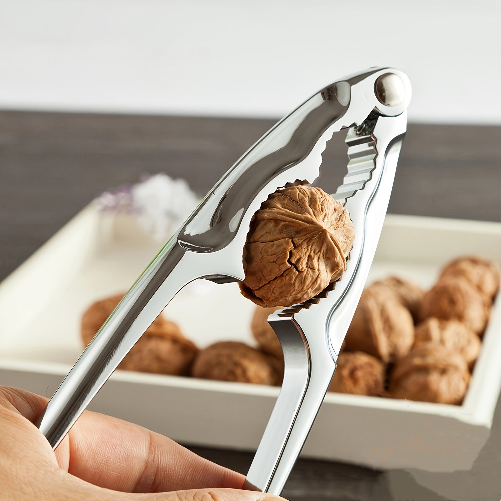 A durable metal kitchen gadget that easily cracks walnuts, hazelnuts, and more - the ultimate versatile nutcracker tool.