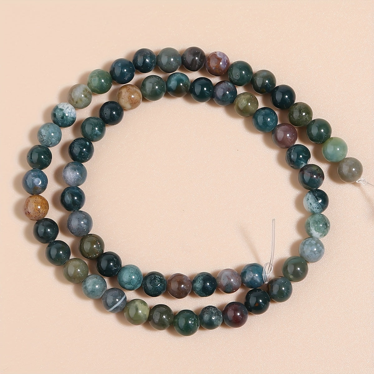 Indian Agate Round Loose Spacer Beads available in natural stone, perfect for DIY bracelet making. Each strand measures 15 inches in length with bead sizes of 4, 6, 8, 10, and 12mm. Ideal for creating unique jewelry accessories.