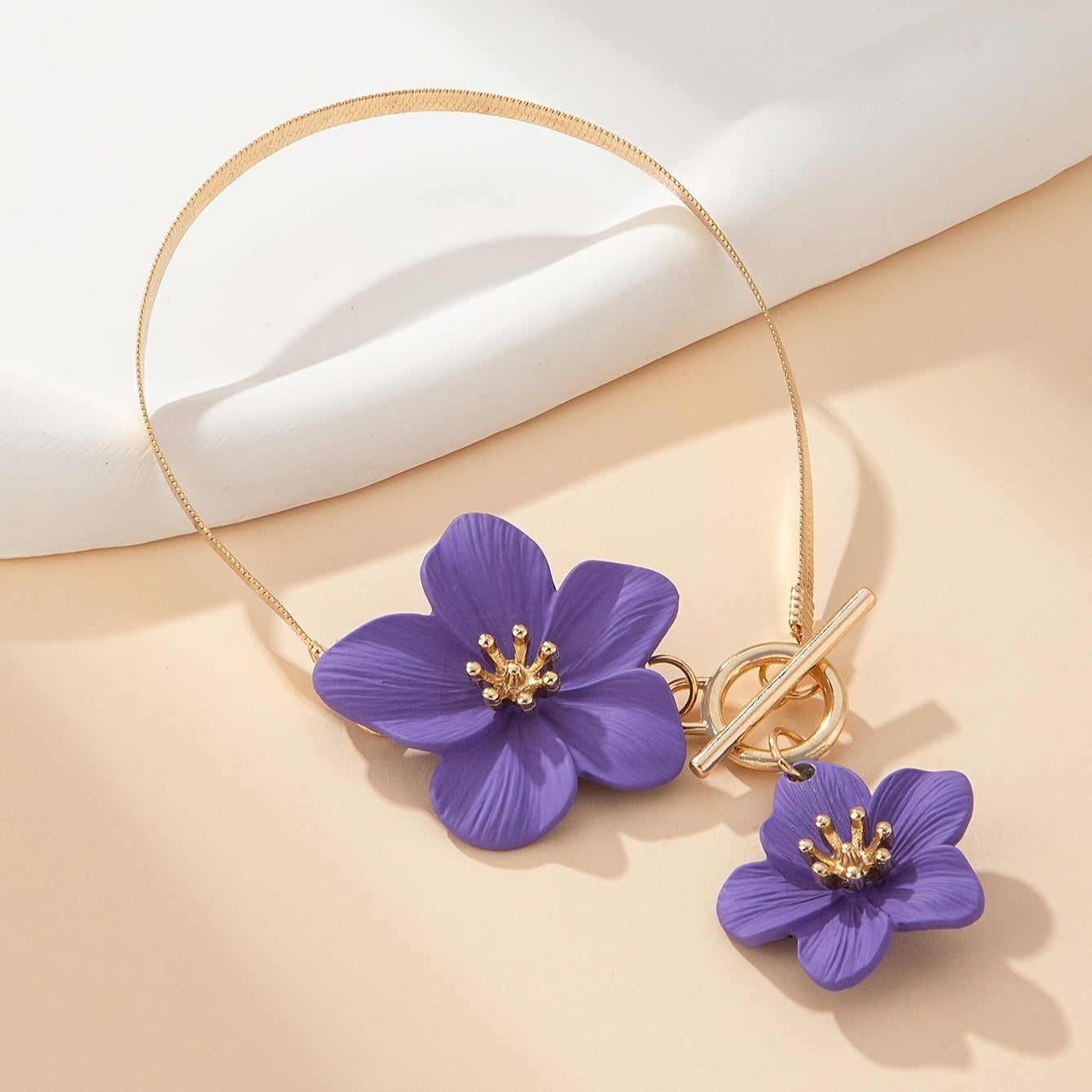 Stylish gold-tone anklet with white flower charms, perfect for vacations and everyday wear.