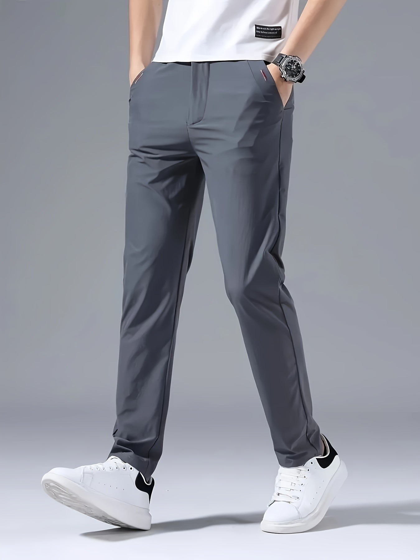 Men's slim fit casual pants made of breathable nylon fabric with pockets and embroidery. Suitable for outdoor and daily wear in a solid color basic style. Features zippered waist for