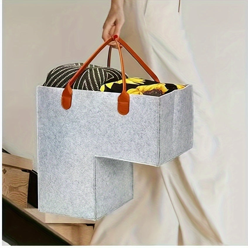 Felt storage basket with leather handles, foldable open top for organizing clothes and toys at home.