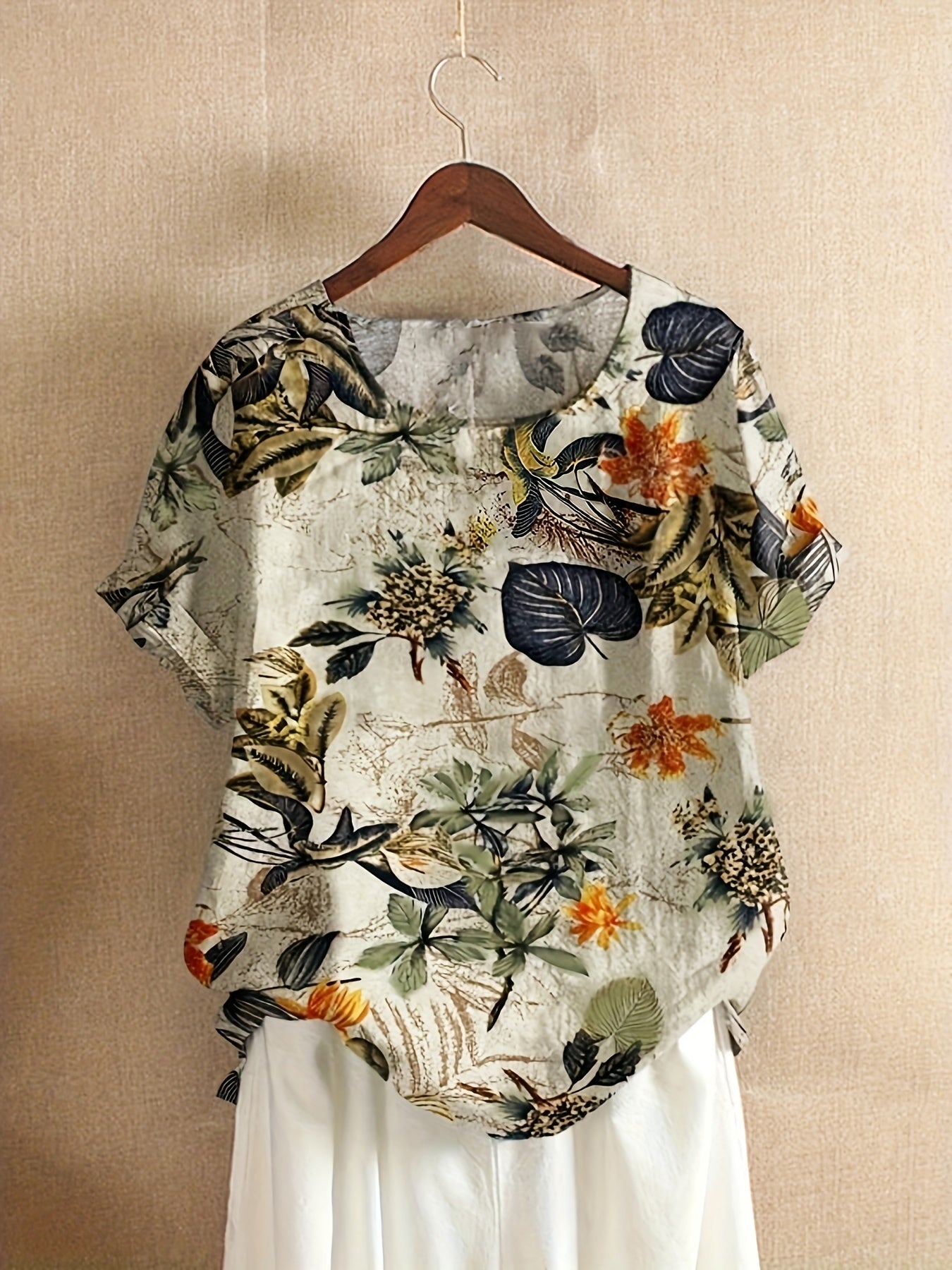 Plus size tropical print blouse for women, casual and loose fit, short sleeve, round neck, polyester blend, machine washable, vibrant floral design with asymmetrical hem.