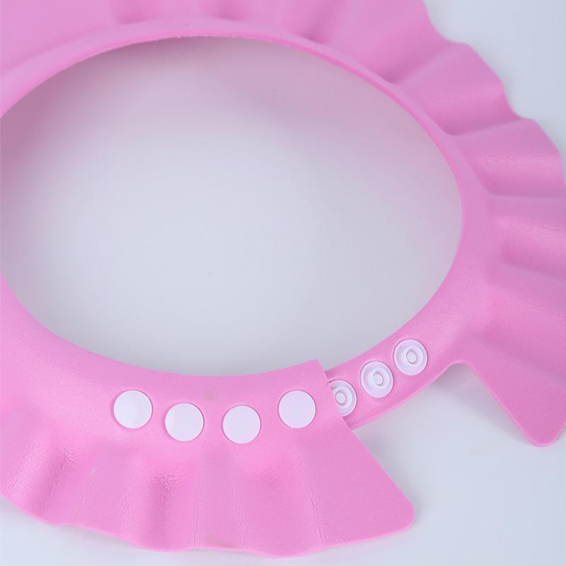 Adjustable baby shampoo cap in pink and yellow, made of soft polyester, protects eyes and ears during hair washing. Ideal for bathing and hair care.