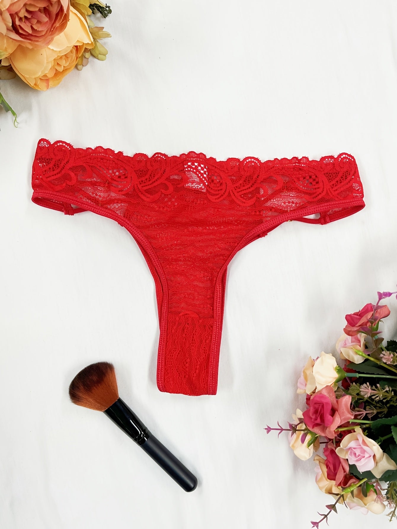 Red lace thong panties for women with floral pattern and scalloped trim. Made of breathable polyester blend that is semi-sheer and hand washable.