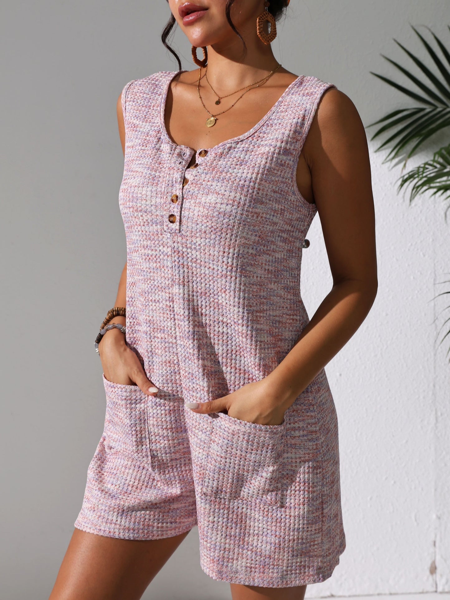 Sleeveless waffle knit romper with pockets for plus-size women in pastel pink. Comfortable and stretchy, perfect for spring/summer.