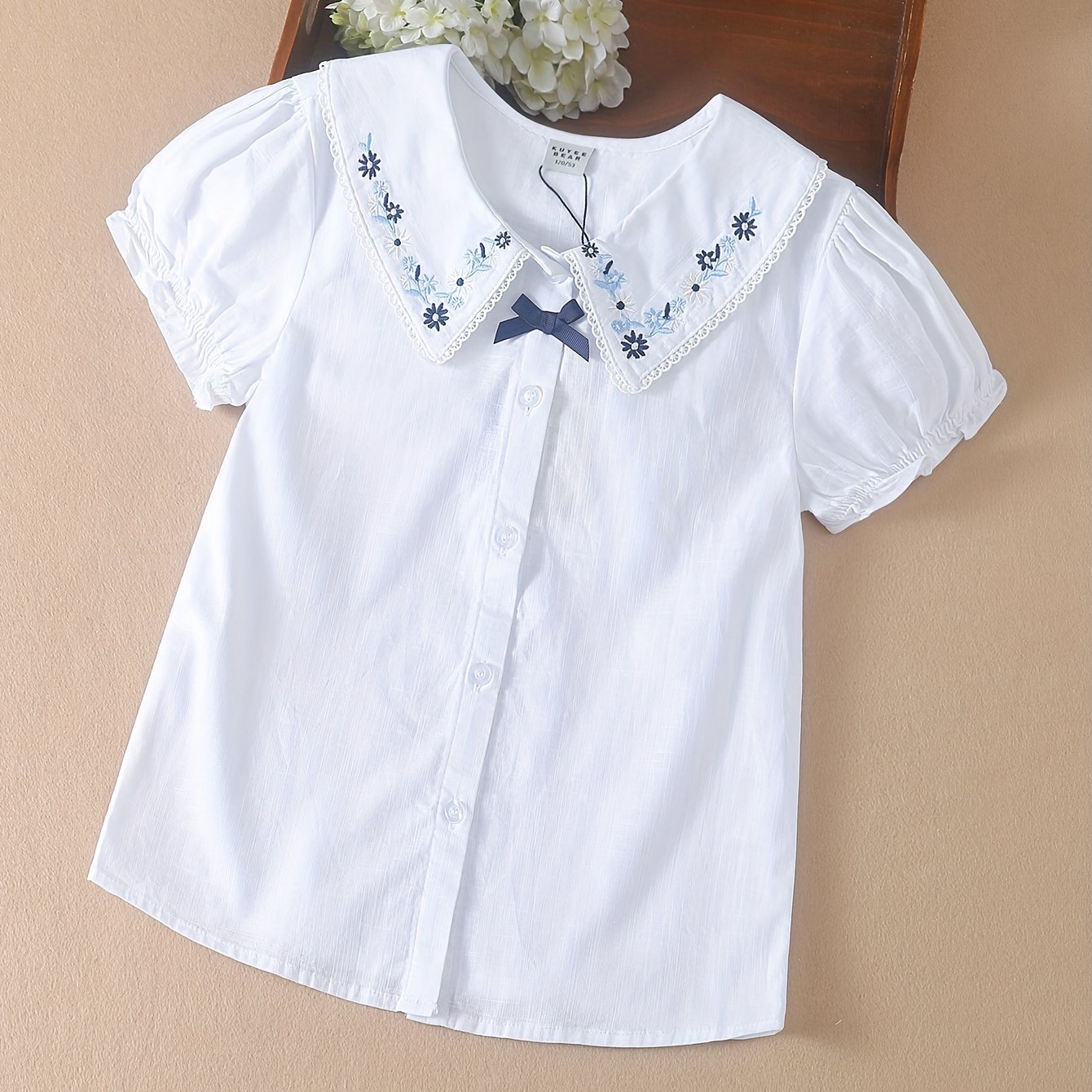 White cotton summer blouse with preppy doll collar, embroidered floral detail, Korean style, for middle and big kids.