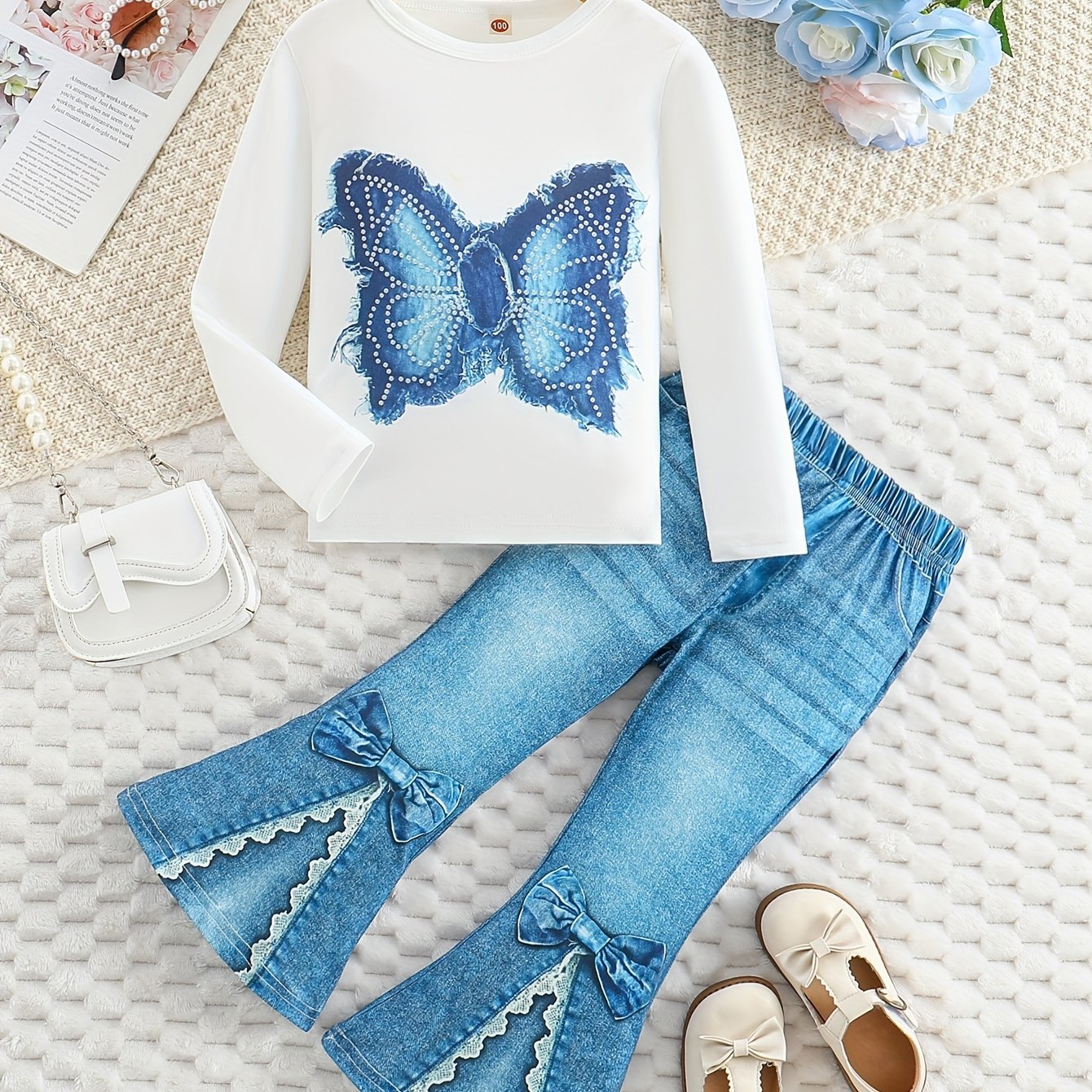 Girls' outfit set includes a long sleeve top with butterfly print and flared faux denim pants with a bow detail. Made of slight stretch knit fabric with an animal pattern, this regular fit