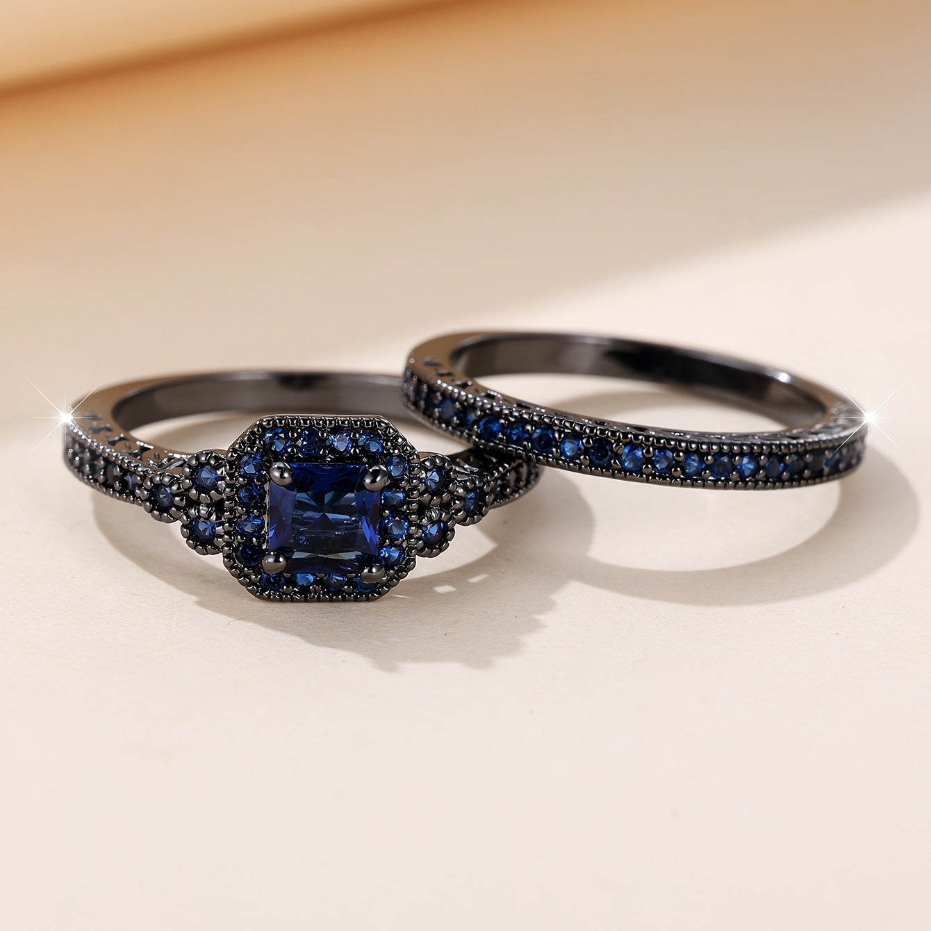 Set of 2 elegant promise rings featuring a halo ring with a dark blue zirconia stone and an eternity ring, perfect for engagement or wedding jewelry. Ideal for brides to enhance their evening party attire.