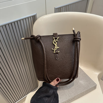 Elegant women's crossbody bucket bag with vintage style, adjustable strap, zipper closure, polyester lined. Available in black, white, dark brown, light brown. Suitable for work, commute