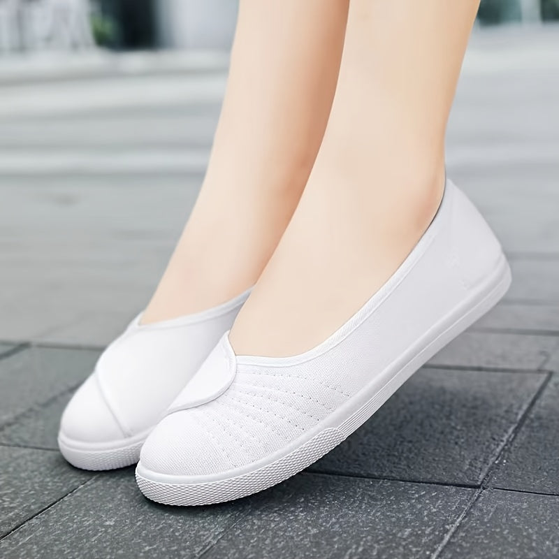 Women's white slip-on sneakers with breathable fabric upper, rubber sole, round toe, and sporty design.