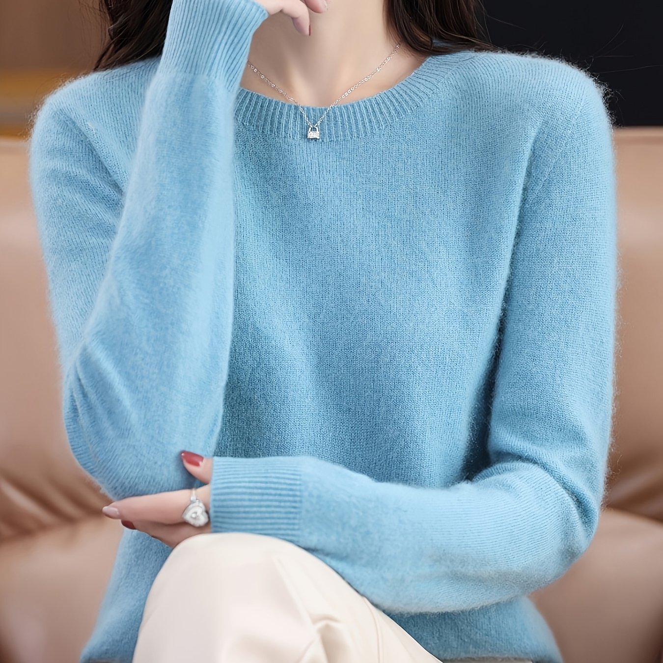 Stylish women's merino wool sweater with cozy crew neck, long sleeves, and solid color knit design for fall/winter.